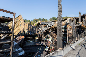 Burned damaged ruins of destroyed supermarket metallic facade arson investigation insurance