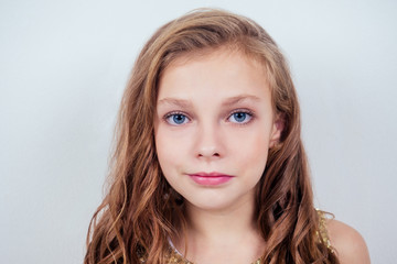 Naklejka premium Portrait of a lovely little teenager schoolgirl girl curly blonde hairstyle