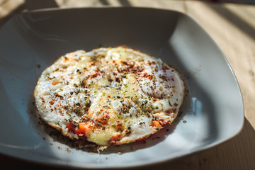 Fried eggs with cheese and spices