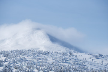 Mountain peak in the snow and clouds