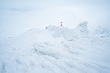 Naklejka na ściany i meble Photographer in winter trekking on the snowy mountains