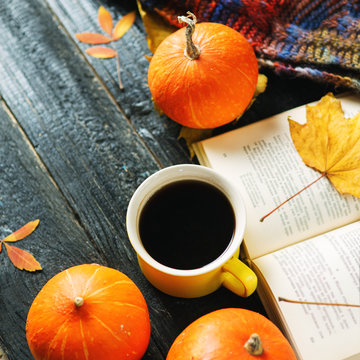 Autumn hot coffee on vintage background with pumpkins, book and leaves