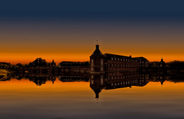 Fototapeta na wymiar Castle with park in the sunset with wonderful reflection