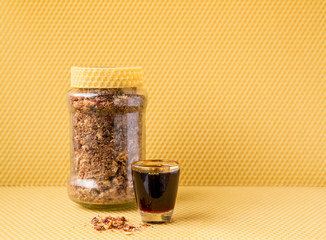 Propolis or bee glue is a resinous mixture that honey bees produce by mixing saliva and beeswax with exudate gathered from tree buds, sap flows, or other botanical sources.