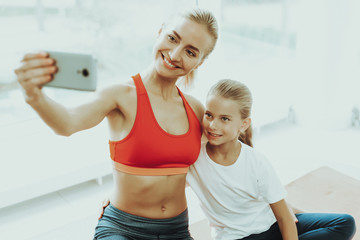 Mum And Daughter Are Doing Selfie On Gym Carpet.