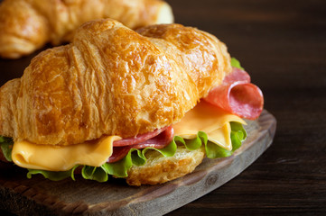 Croissant with sausage cheese and herbs. on dark background