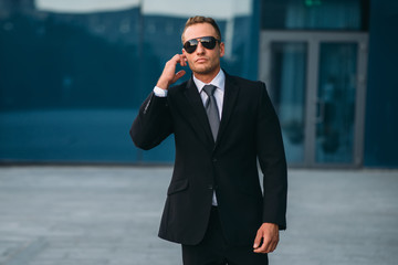 Male bodyguard uses security earpiece outdoors