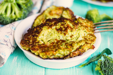 fried broccoli pancakes on a plate on a wooden board