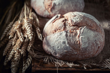 Fresh loaf of bread on dark and rustic table