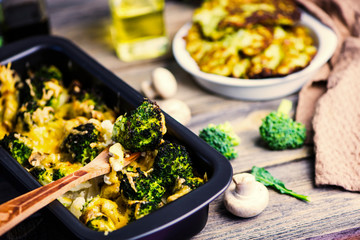 baked broccoli with cheese and mushrooms and broccoli pancakes on a wooden board