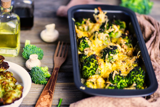 baked broccoli with cheese and mushrooms and broccoli pancakes on a wooden board