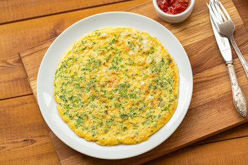 Delicious scrambled eggs with herbs. Omelet for Breakfast. Scrambled eggs with grated cheese and herbs. Egg dish for Breakfast.