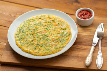 Delicious scrambled eggs with herbs. Omelet for Breakfast. Scrambled eggs with grated cheese and herbs. Egg dish for Breakfast.