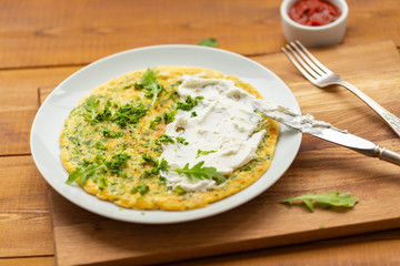 Omelette with herbs, soft cheese, grilled sausages and tomato sauce. Delicious breakfast