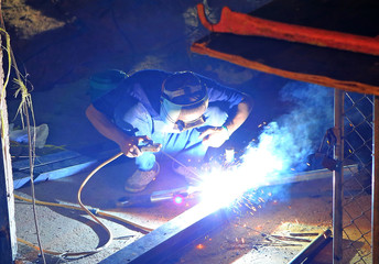 Welder with protect mask, welding metal and sparks working.
