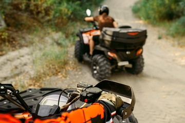 Fototapeta na wymiar Two quad bike riders travels in forest, front view