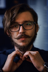 Portrait of a guy close-up. The guy is looking forward. A man straightens his shirt.