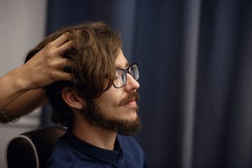 Girl makes head massage to man in barbershop