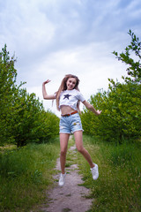 a young teenager girl with curled hair jumping