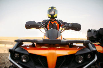 Fototapeta premium Rider in helmet on quad bike, front view, closeup