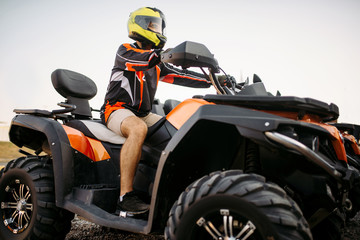 Fototapeta na wymiar Rider in helmet on quad bike, front view, closeup