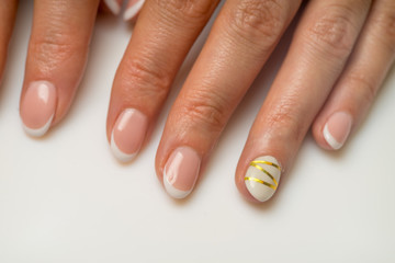French manicure and nail gel Polish. The decoration of the nail white and gold decor. Top view Close-up photography