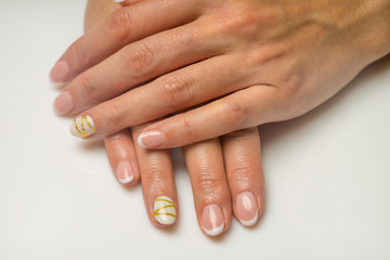 French manicure and nail gel Polish. The decoration of the nail white and gold decor. Top view Close-up photography