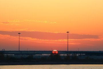 bright sunset with red sun on the background of the port
