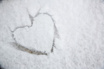 The symbol of the heart, painted on the fresh white snow.drawn heart in the snow.Image of the heart in the snow.