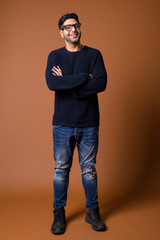 Young handsome Indian man against brown background