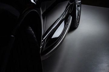 close up view luxury shining black automobile on dark background