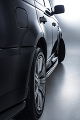 Obraz na płótnie Canvas close up view of black luxury car on grey background