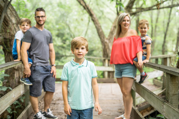 Fototapeta premium happy young family in forest having fun together