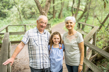 Grandparents with grandkid on summer forest having good time