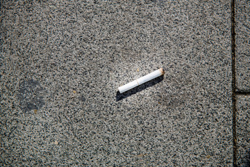 Cigarette butts on the street.Cigarette stub on the floor black background.Cigarette butt off on isolated ground. No people.