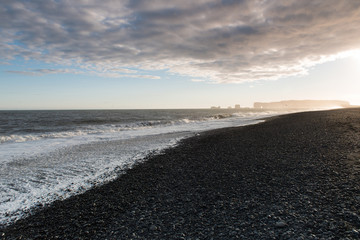 The black sand beach of Reynisfjara and the mount Reynisfjall from the Dyrholaey promontory in the...