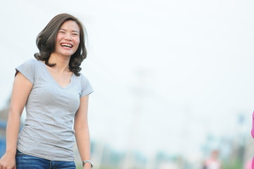 Fototapeta premium Asian girl smiling and feeling happy in the park in a sunny summer day, Have a beautiful day and happy concept.