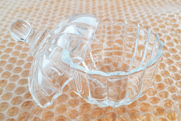 Crystal bowl with lid prepared for packaging with transparent bubble wrap for packaging fragile things, close up, front view