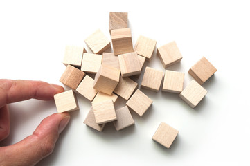 closeup of hand with wooden brick of construction game on white background