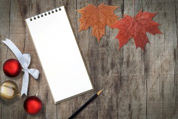 Naklejka na ściany i meble Blank Paper Note Book, Pencil and Autumn Leaves on Wooden Background with Copy Space, Season's Greetings Concept