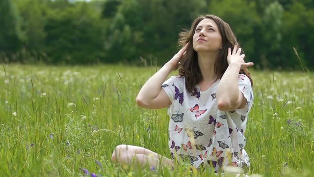 Female on grass enjoying life looking up to sky in summer, joyful lady outdoors