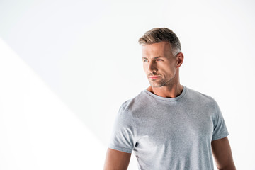 Obraz premium handsome adult man in blank grey t-shirt looking away isolated on white