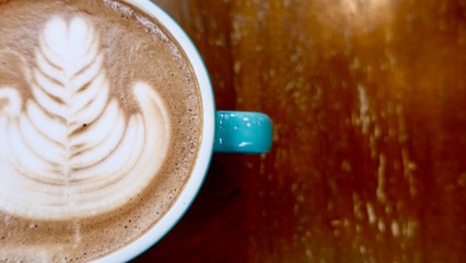 close up of A cup of hot latte art or cappuccino coffee on wooden table  