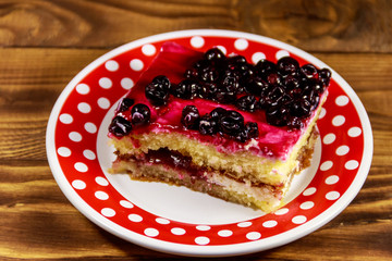 Tasty cheesecake with black currant on wooden table