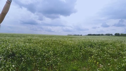 Woman stands in field hands held high female feels nature sense wind sun on skin