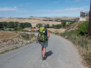Pilgerin auf dem Jakobsweg in weiter Landschaft in Spanien 