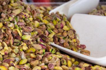 Pistachio nuts without peel and white plastic scoop