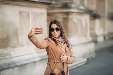 Fototapeta premium Beautiful girl in sunglasses make photo on smartphone. selfie