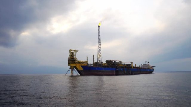 FPSO tanker with burning flare boom. Oil and gas industry production