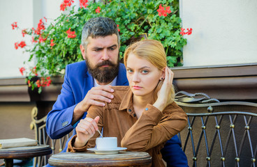 Couple in love drinks espresso during coffee break. Woman and man with serious faces have coffee at...
